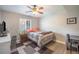 Comfortable bedroom with large window, neutral walls, and a ceiling fan, offering a serene and calming atmosphere at 8893 W Ontario Ave, Littleton, CO 80128