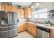 Bright kitchen features stainless steel appliances, wood cabinets, and an eat-in area at 8893 W Ontario Ave, Littleton, CO 80128