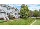 Landscaped townhome with a well-manicured lawn, mature trees, and inviting front entrance at 4070 E 119Th Pl # B, Thornton, CO 80233