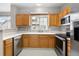 Kitchen with light wood cabinetry, stainless-steel appliances, and a window overlooking the neighborhood at 4070 E 119Th Pl # B, Thornton, CO 80233