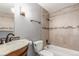 Bright bathroom featuring a shower over tub, decorative tile accent, and wood vanity at 8360 W 87Th Dr # D, Arvada, CO 80005