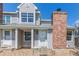 Two-story home featuring a gray exterior, chimney, landscaped front, and white front door at 8360 W 87Th Dr # D, Arvada, CO 80005