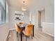 Bright dining area with wood floors, modern lighting, and a view into the adjacent kitchen space at 9363 Amison Cir # 106, Parker, CO 80134