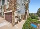 A ground level garage with stone accents and a side entrance to the upper-level floors of a condo at 9363 Amison Cir # 106, Parker, CO 80134