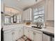 Bright kitchen features white cabinets, quartz countertops, stainless steel appliances, and a view to the living room at 9363 Amison Cir # 106, Parker, CO 80134
