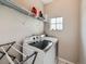 Bright laundry room with modern washer and dryer, plus overhead wire shelving for supplies at 9363 Amison Cir # 106, Parker, CO 80134