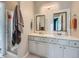 Spacious bathroom features a dual sink vanity, marble accent wall, and glass enclosed shower at 9363 Amison Cir # 106, Parker, CO 80134