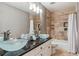 Modern bathroom with dual vessel sinks, stone tile shower, and decorative lighting at 16302 Parkside Dr, Parker, CO 80134