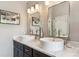 Modern bathroom with dual vessel sinks, marble countertops, and decorative lighting fixtures at 16302 Parkside Dr, Parker, CO 80134