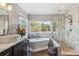 Luxurious bathroom with a soaking tub, glass-enclosed shower, and elegant marble finishes at 16302 Parkside Dr, Parker, CO 80134