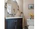 Charming powder room with round mirror, dark vanity, and decorative accents at 16302 Parkside Dr, Parker, CO 80134