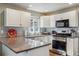 Well-lit kitchen featuring white cabinets, stainless steel appliances, and a gray subway tile backsplash at 16302 Parkside Dr, Parker, CO 80134