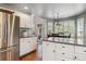Open kitchen area with stainless steel refrigerator, white cabinets, and an adjacent dining area at 16302 Parkside Dr, Parker, CO 80134