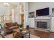 Cozy living room boasts a brick fireplace, a large TV, and plenty of natural light, perfect for relaxing after a long day at 16302 Parkside Dr, Parker, CO 80134