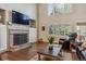 The living room has hardwood floors, a brick fireplace, built-in shelving, and an oversized window with plantation shutters at 16302 Parkside Dr, Parker, CO 80134