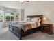 Spacious main bedroom with a large bed, bay windows, and a dark wood nightstand at 16302 Parkside Dr, Parker, CO 80134