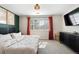 A cozy bedroom featuring a dark green accent wall and orange-red curtains at 4947 Stoneham Ave, Castle Rock, CO 80104