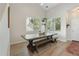 Bright dining area with a long wooden table, bench seating, wood floors, and large windows for ample natural light at 4947 Stoneham Ave, Castle Rock, CO 80104