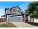 Charming two-story home with a gray exterior, red shutters, a well-manicured lawn, and an attached two-car garage at 4947 Stoneham Ave, Castle Rock, CO 80104