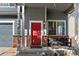 Inviting front porch with brick accents, a red door, white columns, and a cozy bench, creating a welcoming entrance at 4947 Stoneham Ave, Castle Rock, CO 80104