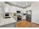 Modern kitchen boasts stainless steel appliances, white cabinetry, and wooden floors at 4947 Stoneham Ave, Castle Rock, CO 80104