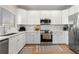 Bright kitchen features white cabinets, stainless steel appliances, and sleek countertops at 4947 Stoneham Ave, Castle Rock, CO 80104