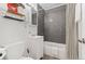 Well-lit bathroom with a vanity, toilet, and a shower featuring gray tile at 739 S Utica St, Denver, CO 80219