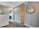 Hallway with a decorative mirror, door, and view into another room at 1179 S Alton Ct, Denver, CO 80247