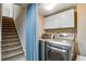 Convenient laundry area with modern washer and dryer, plus storage cabinets at 1179 S Alton Ct, Denver, CO 80247