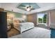 Bright primary bedroom features a bed, ceiling fan, and outdoor views at 1179 S Alton Ct, Denver, CO 80247