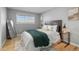 Cozy bedroom featuring a queen bed with stylish bedding, wood floors and natural light from a window at 2572 Beech Ct, Golden, CO 80401