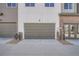 Modern townhome garages with three bays and brick accents at 6827 Huddersfield Ln, Castle Pines, CO 80108