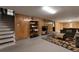 Finished basement with wood-paneled walls, carpeted area, storage, and a seating area at 2520 Dover Ct, Lakewood, CO 80215