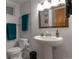 Fresh and modern bathroom featuring a pedestal sink, updated fixtures, and ample lighting at 2520 Dover Ct, Lakewood, CO 80215