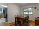 Sunny dining room with hardwood floors, view to kitchen, wooden table and mid-century modern decor at 2520 Dover Ct, Lakewood, CO 80215