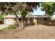 Charming brick home featuring an attached garage, a covered front porch, and mature landscaping at 2520 Dover Ct, Lakewood, CO 80215