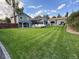 Large backyard with mature landscaping, deck, sunroom, detached garage, and lush green lawn at 8700 S Ammons St, Littleton, CO 80128