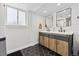 Modern bathroom with double sink vanity, matte black fixtures and hexagonal tile floor at 8700 S Ammons St, Littleton, CO 80128
