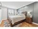 Inviting bedroom with hardwood floors, soft lighting, and a comfortable bed with neutral bedding at 8700 S Ammons St, Littleton, CO 80128