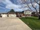 Charming multi-level home with a well-manicured lawn and a three-car garage at 8700 S Ammons St, Littleton, CO 80128