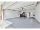 Epoxy-floored garage with storage, workshop space, a tv for entertainment, and access to the backyard at 8700 S Ammons St, Littleton, CO 80128