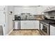 Modern kitchen boasts sleek white cabinets, stainless steel appliances, and elegant countertops at 8700 S Ammons St, Littleton, CO 80128