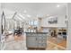 Open kitchen with island flowing into a sunroom with skylights and dining area at 8700 S Ammons St, Littleton, CO 80128