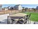 The spacious backyard features an outdoor dining set, patio, manicured lawn, fire pit, and beautiful neighborhood views at 16722 Chilton Dr, Mead, CO 80542