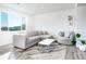 Bright living room with large windows, neutral-colored furniture, stylish coffee table, and a decorative plant at 16722 Chilton Dr, Mead, CO 80542