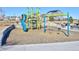 Community playground with slides, climbing nets, and swings, with modern residences in the background at 16722 Chilton Dr, Mead, CO 80542