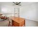 Upstairs open bonus area featuring neutral carpet, wooden desk, a ceiling fan, and view of staircase at 10115 Cook St, Thornton, CO 80229