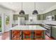 Modern kitchen with stainless steel appliances, olive-green cabinetry, and a large center island at 10115 Cook St, Thornton, CO 80229