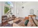 Bright living room with large arched window, hardwood floors, and leather furniture at 10115 Cook St, Thornton, CO 80229
