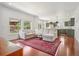 Bright living room featuring a neutral sectional sofa, hardwood floors, and views into kitchen and landscaped backyard at 10115 Cook St, Thornton, CO 80229